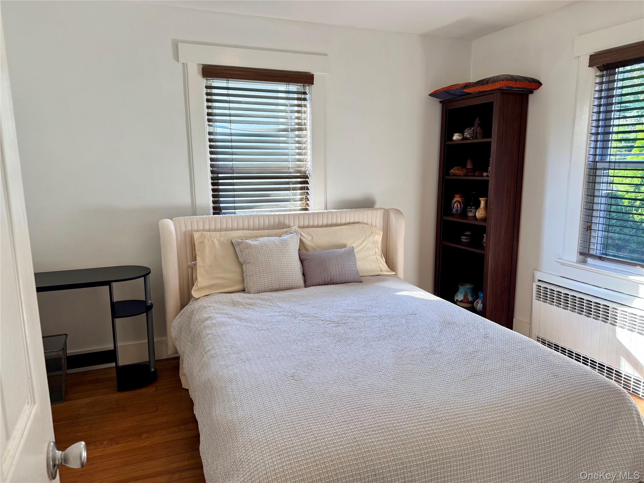 25 School Street Port Washington, NY 11050 - Photo 11 of 25 Bedroom featuring wood finished floors and radiator