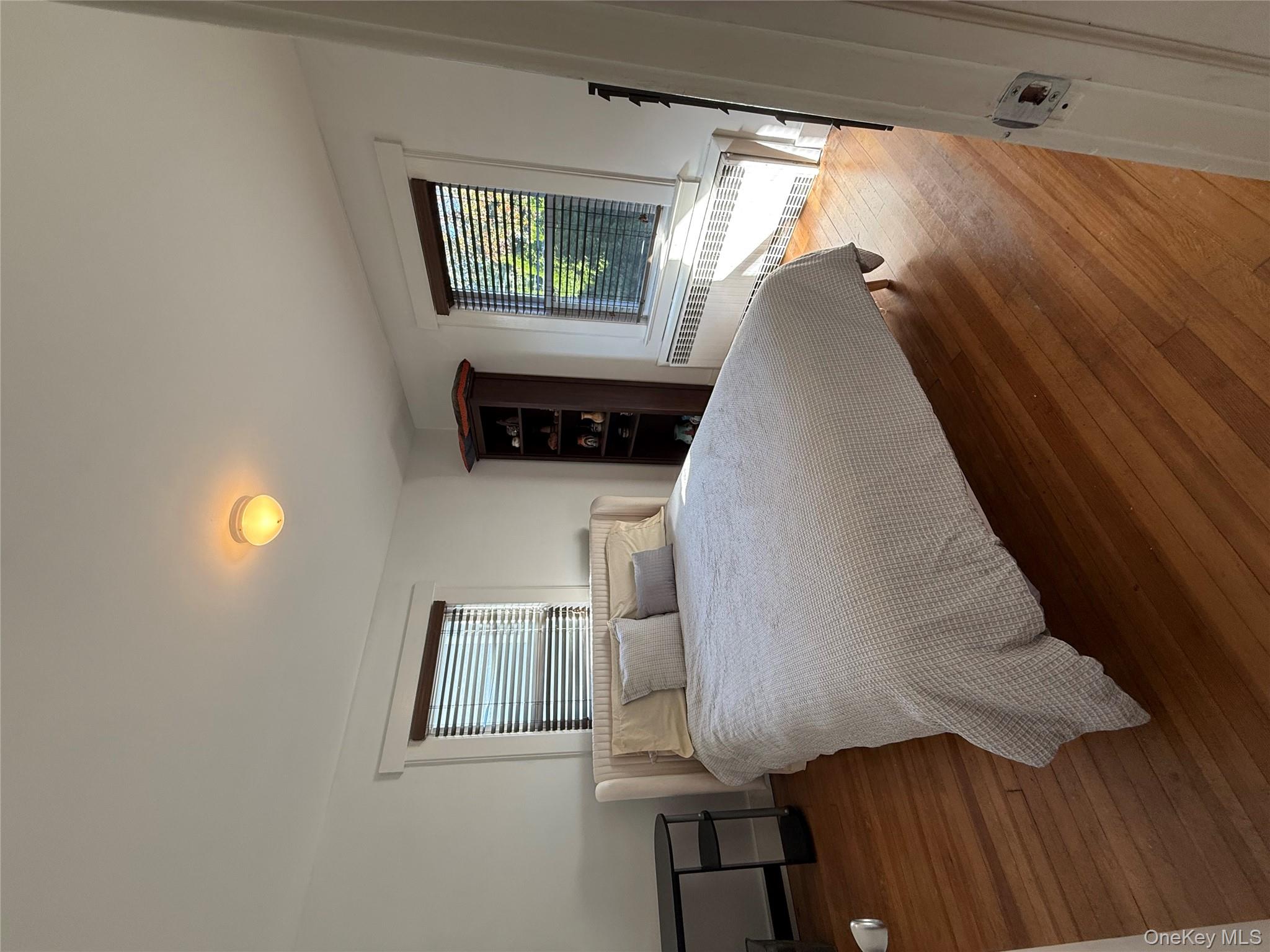 25 School Street Port Washington, NY 11050 - Photo 17 of 25 Bedroom featuring radiator heating unit and wood-type flooring