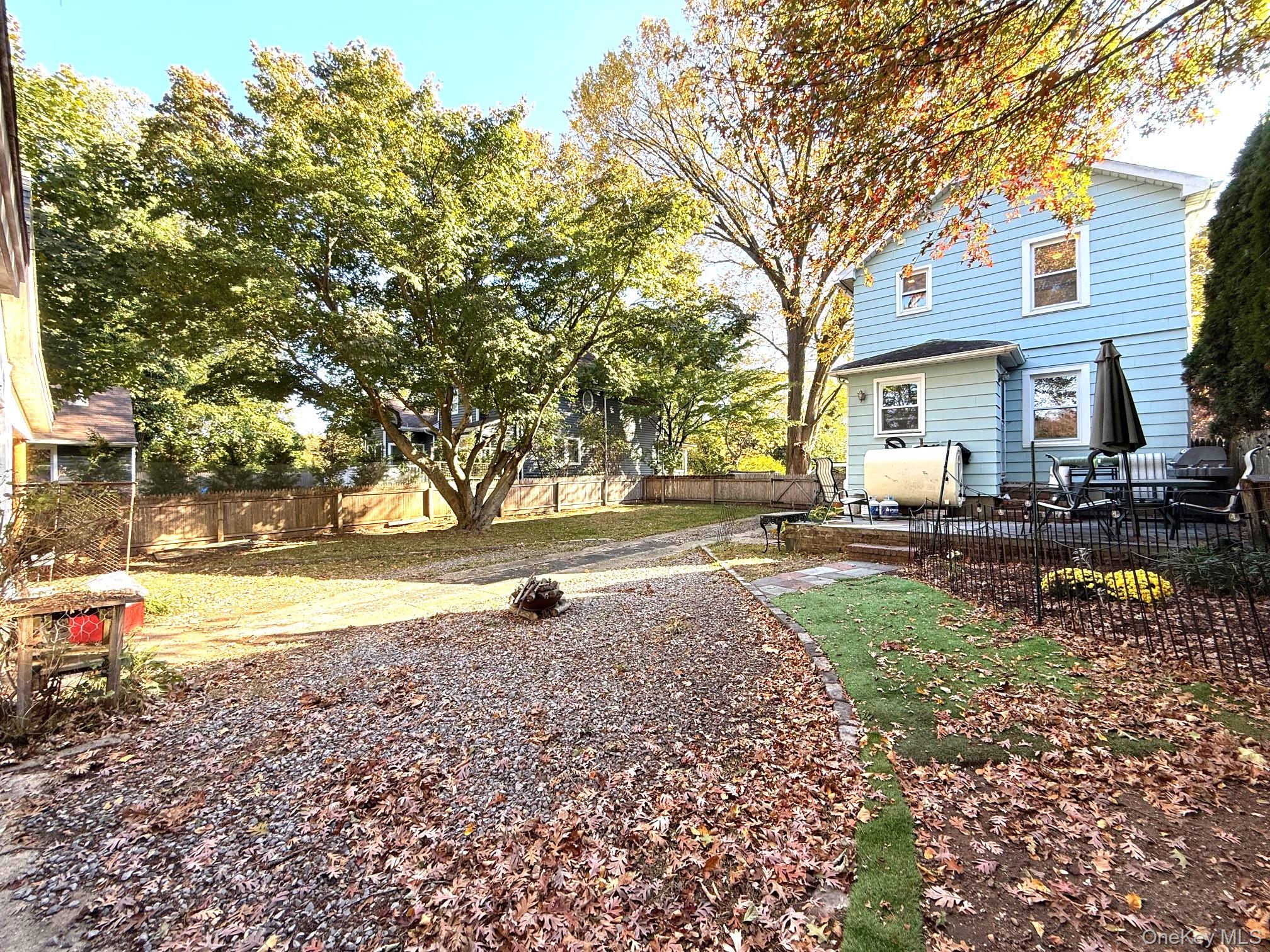 25 School Street Port Washington, NY 11050 - Photo 3 of 25 Fenced backyard featuring oil tank and a patio