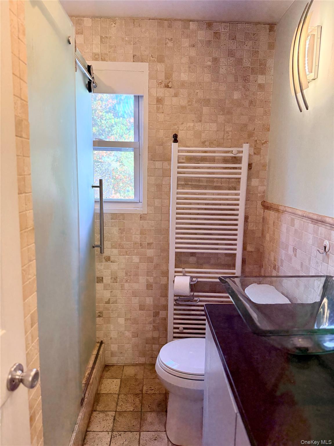 25 School Street Port Washington, NY 11050 - Photo 9 of 25 Bathroom with tile walls, radiator heating unit, vanity, a shower stall, and a towel warming rack