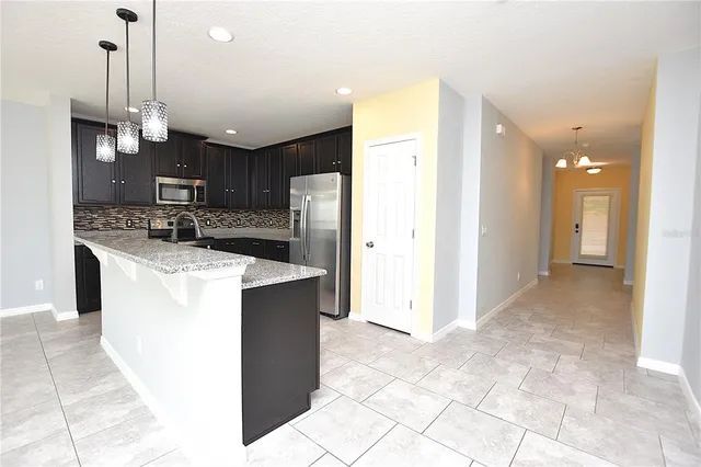 a kitchen with kitchen island a sink a counter and stainless steel appliances