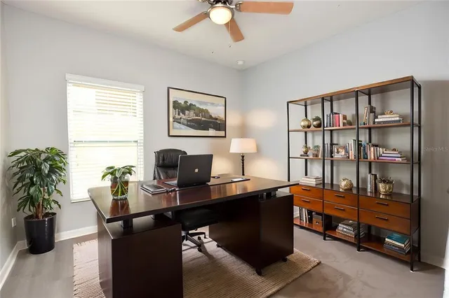 a view of a workspace with furniture and a window