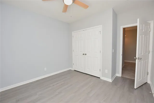 an empty room with wooden floor and window