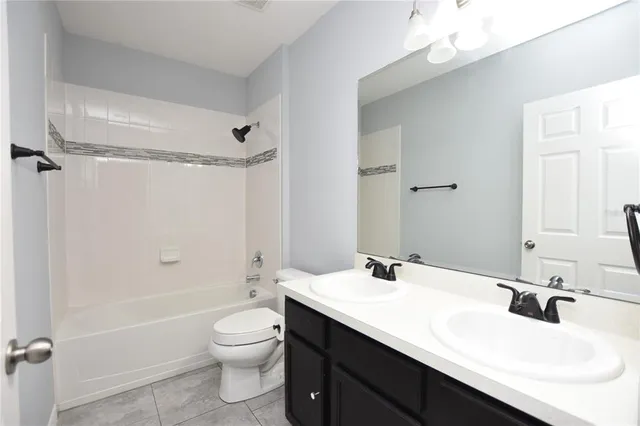 a bathroom with a double vanity sink toilet mirror and bathtub
