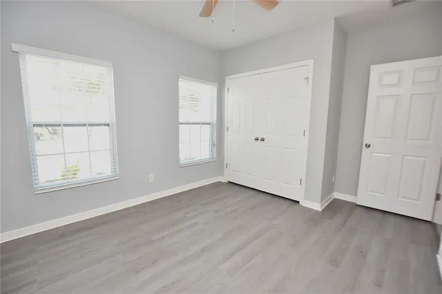 an empty room with wooden floor and windows