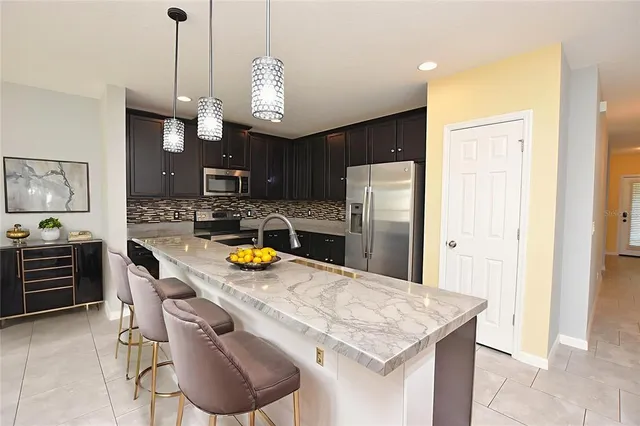 a kitchen with stainless steel appliances granite countertop a sink and a refrigerator