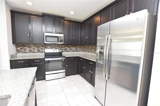a kitchen with a refrigerator and a stove