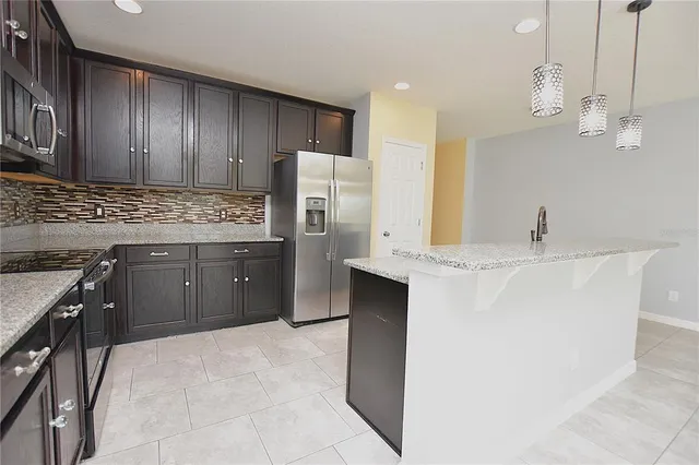 a kitchen with stainless steel appliances a sink stove and refrigerator