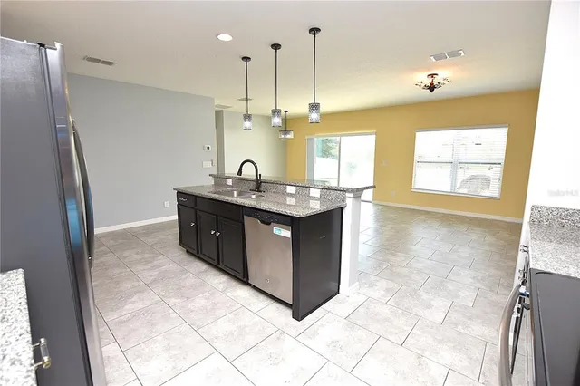 a kitchen with stainless steel appliances granite countertop a sink and a refrigerator