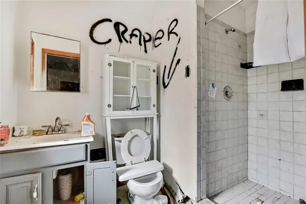 a bathroom with a toilet sink vanity and mirror