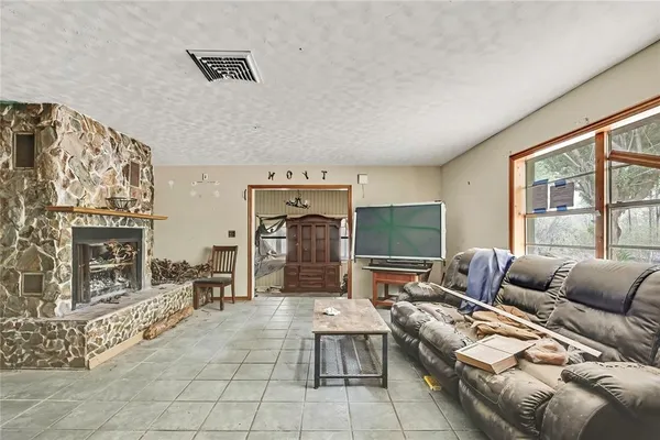 a living room with furniture large window and fireplace