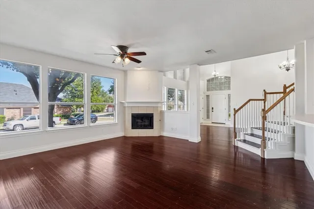 a view of empty room with wooden floor fireplace and a window