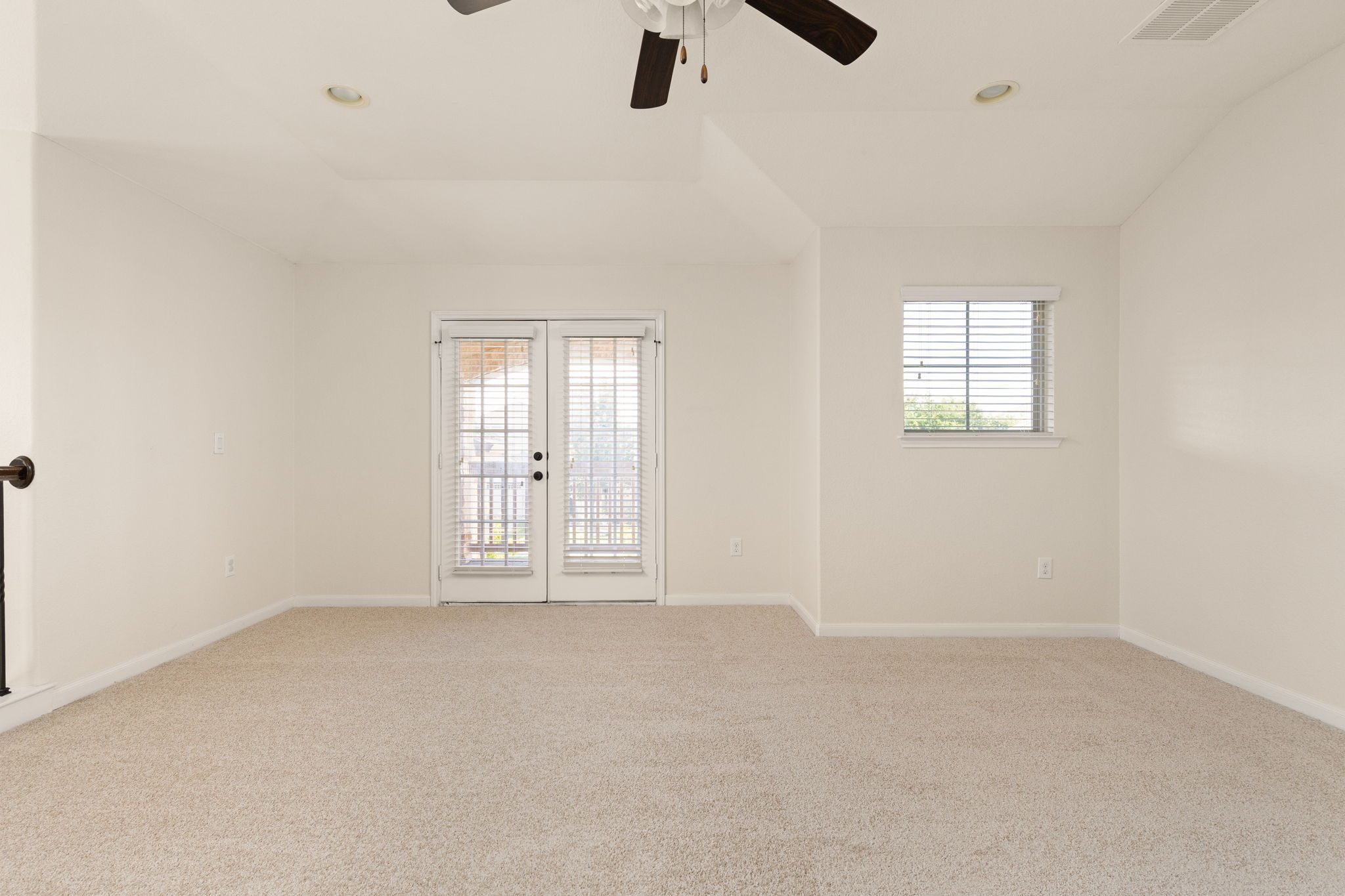 2400 Leonards Pass Leander, TX 78641 - Photo 21 of 40 A versatile living area features plush carpeting and direct outdoor access through double French doors.
