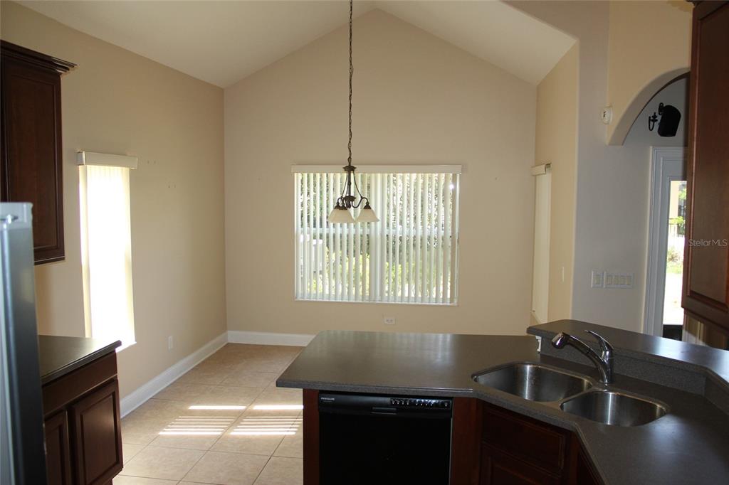 6833 Dolce Way Orlando, FL 32819 - Photo 15 of 28 a kitchen with a sink stove and microwave