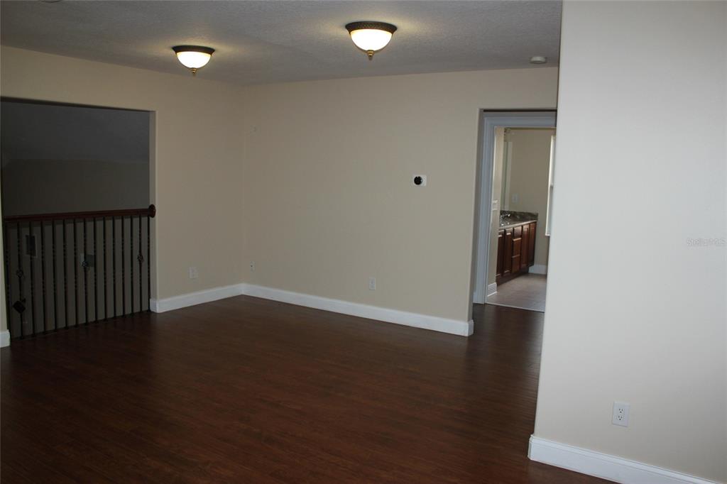 6833 Dolce Way Orlando, FL 32819 - Photo 17 of 28 an empty room with wooden floor and windows