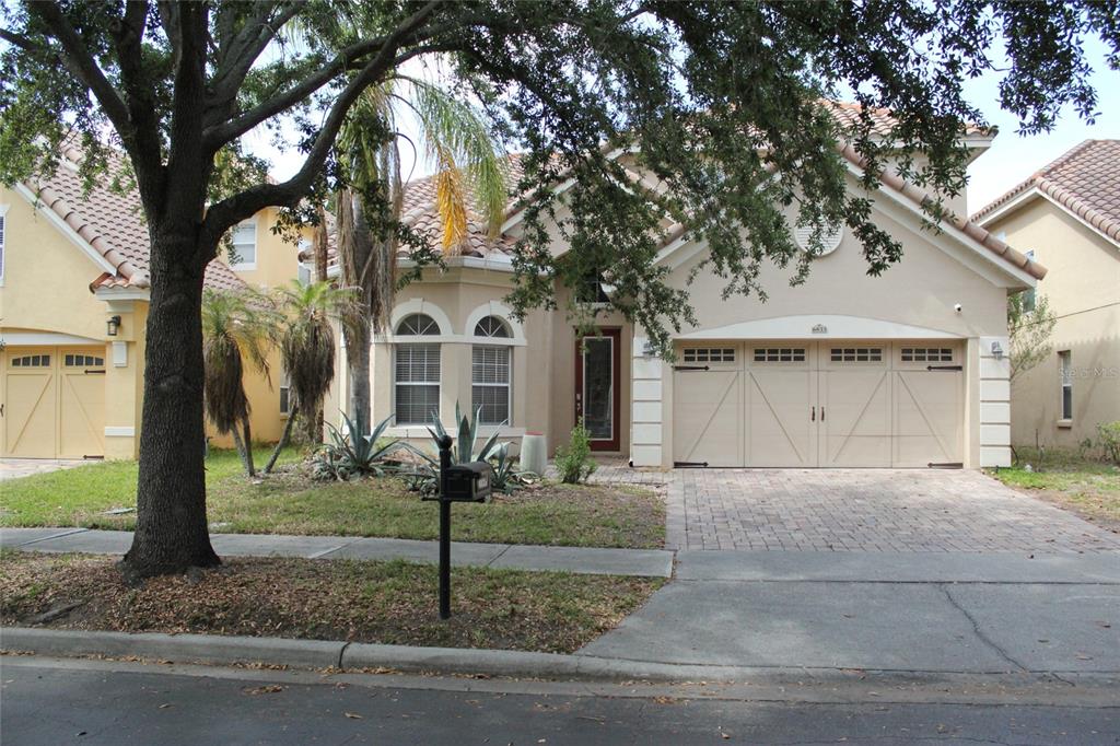 6833 Dolce Way Orlando, FL 32819 - Photo 2 of 28 a front view of a house with garden and trees