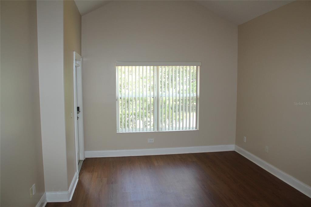 6833 Dolce Way Orlando, FL 32819 - Photo 21 of 28 an empty room with wooden floor and windows
