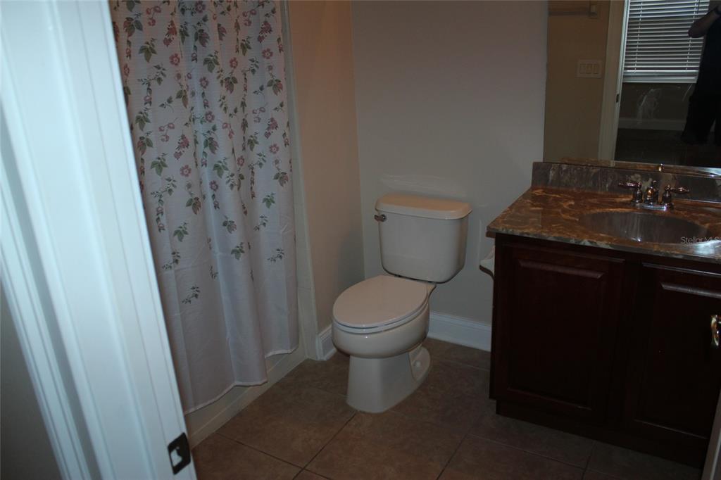 6833 Dolce Way Orlando, FL 32819 - Photo 28 of 28 a bathroom with a granite countertop toilet and a sink