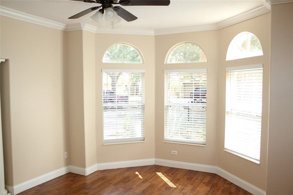 6833 Dolce Way Orlando, FL 32819 - Photo 4 of 28 a view of a bedroom with wooden floor and window