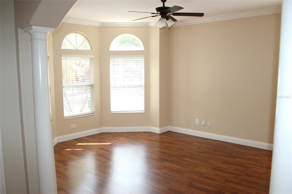 6833 Dolce Way Orlando, FL 32819 - Photo 5 of 28 a view of empty room with wooden floor and fan