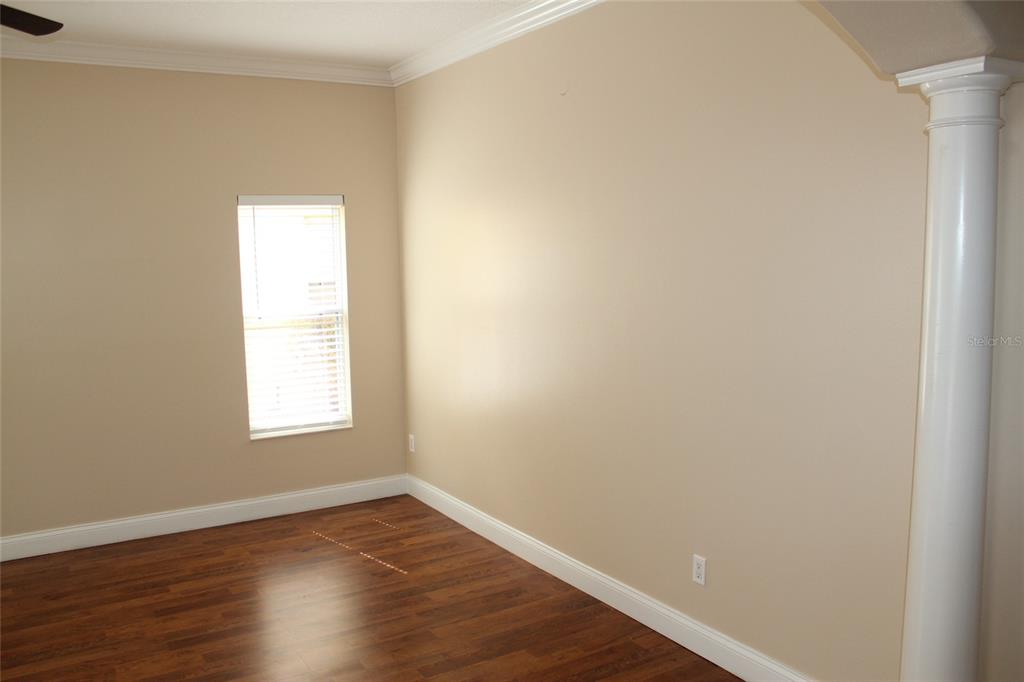 6833 Dolce Way Orlando, FL 32819 - Photo 6 of 28 an empty room with wooden floor and windows