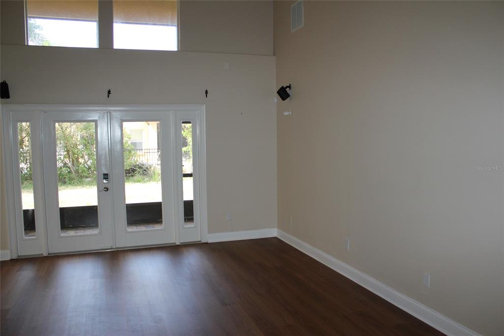 6833 Dolce Way Orlando, FL 32819 - Photo 8 of 28 wooden floor in an empty room with a window