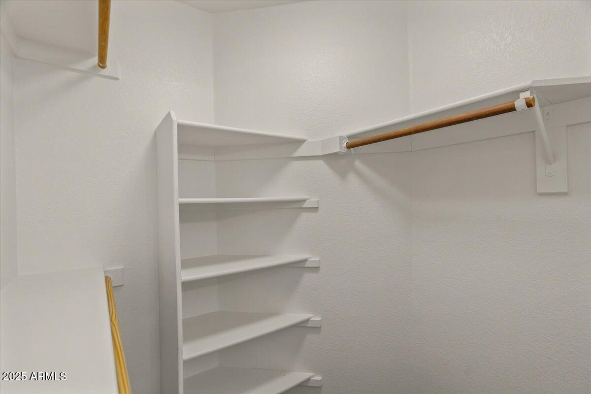 9163 West St John Road Peoria, AZ 85382 - Photo 23 of 38 a view of walk in closet with empty racks
