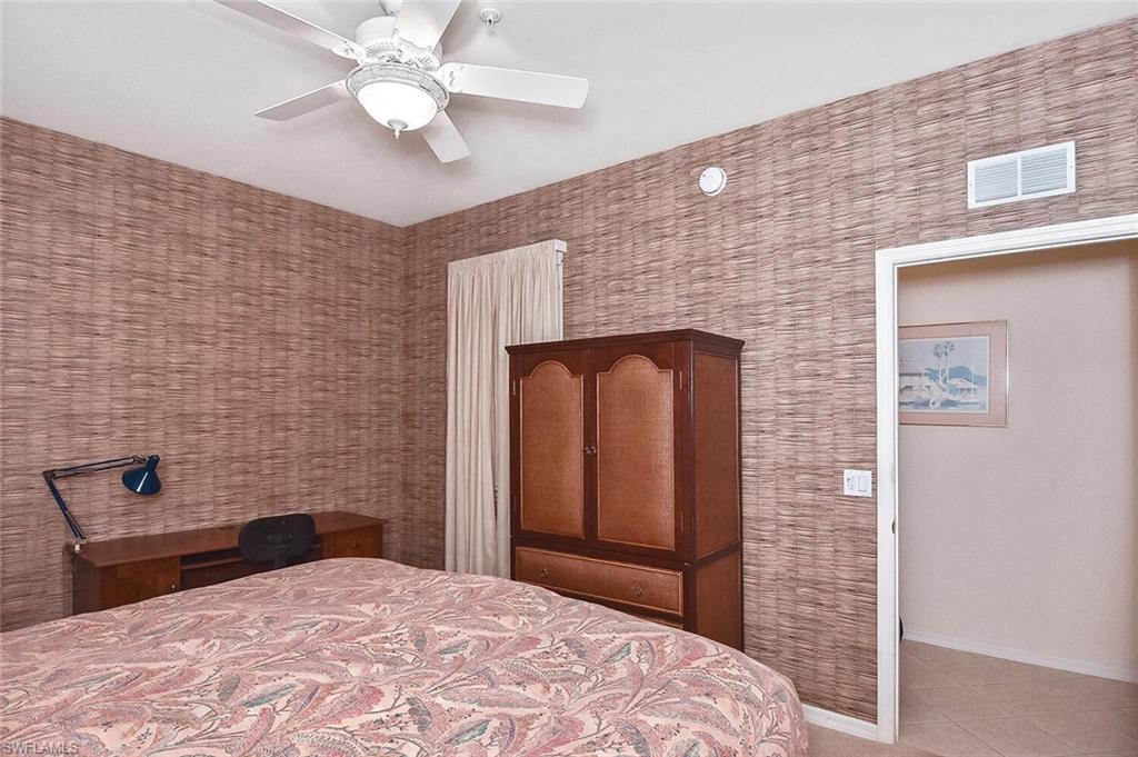 3830 Sawgrass Way, Unit 2946 Naples, FL 34112 - Photo 12 of 49 a bedroom with a bed and a television