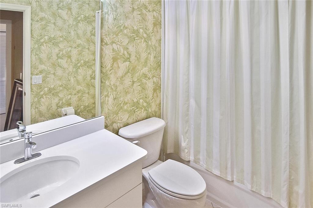 3830 Sawgrass Way, Unit 2946 Naples, FL 34112 - Photo 13 of 49 a bathroom with a toilet a sink and a mirror