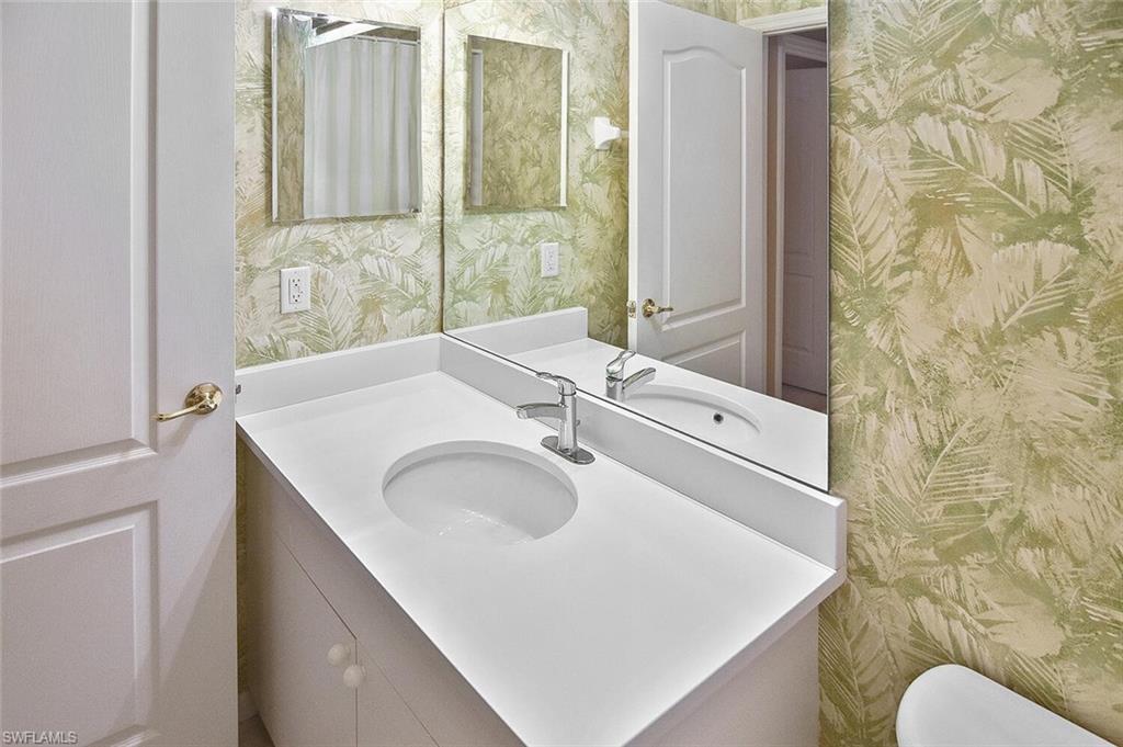 3830 Sawgrass Way, Unit 2946 Naples, FL 34112 - Photo 14 of 49 a bathroom with a sink and a mirror