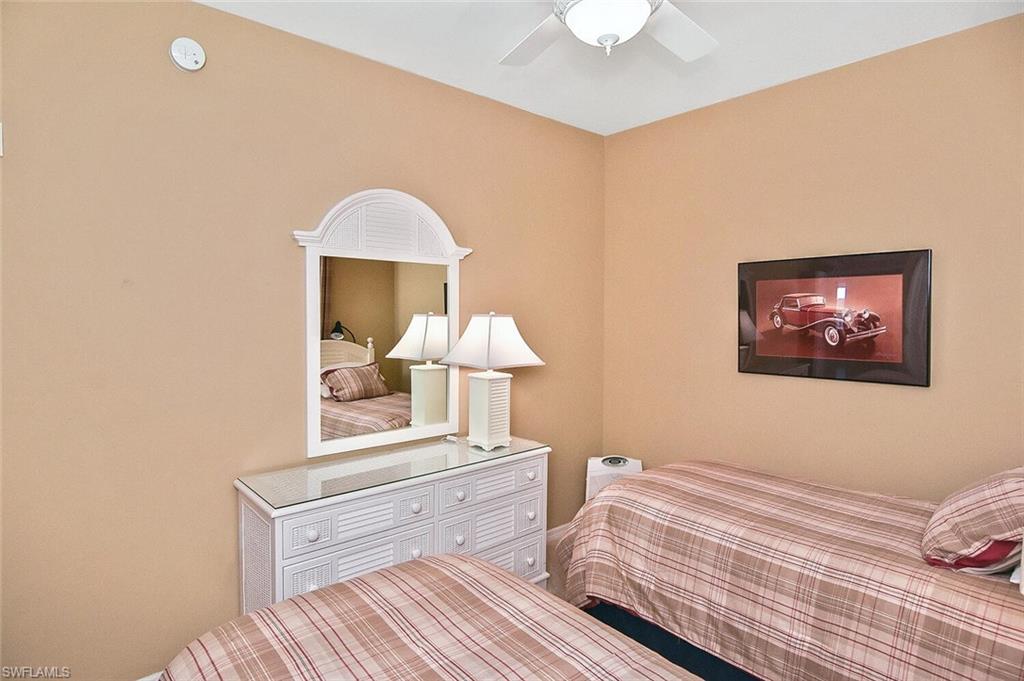 3830 Sawgrass Way, Unit 2946 Naples, FL 34112 - Photo 16 of 49 a bedroom with a bed and a chandelier