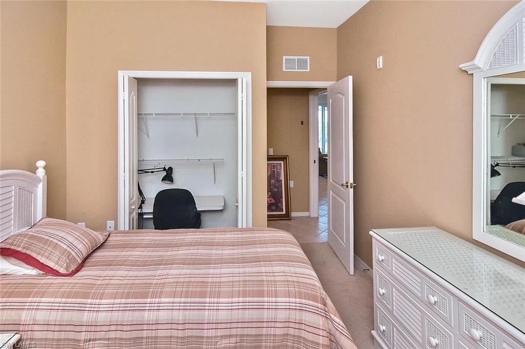 3830 Sawgrass Way, Unit 2946 Naples, FL 34112 - Photo 17 of 49 a bedroom with a bed and a mirror
