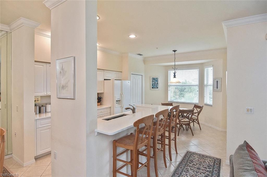 3830 Sawgrass Way, Unit 2946 Naples, FL 34112 - Photo 20 of 49 a view of a a dining room with furniture window and wooden floor