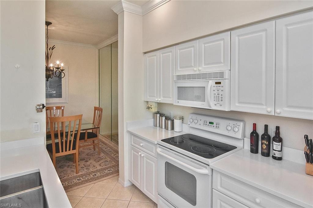 3830 Sawgrass Way, Unit 2946 Naples, FL 34112 - Photo 26 of 49 a kitchen with white cabinets and appliances