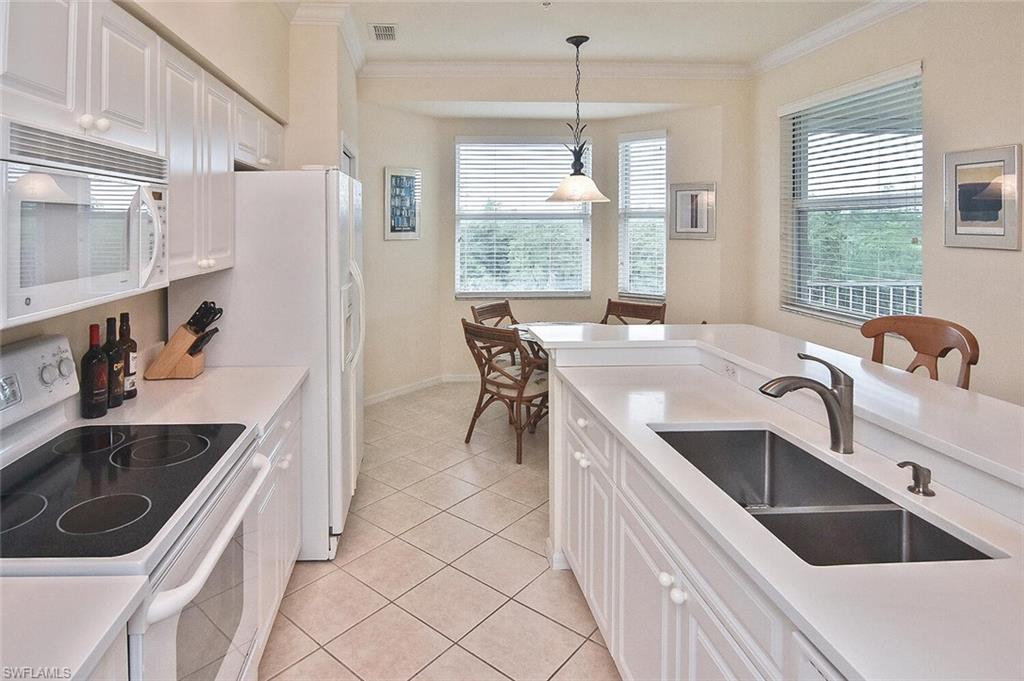 3830 Sawgrass Way, Unit 2946 Naples, FL 34112 - Photo 27 of 49 a kitchen with a stove a sink and a refrigerator
