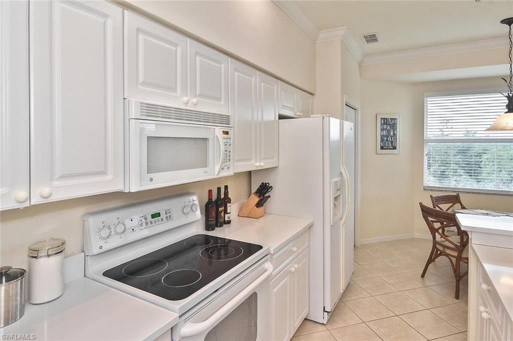 3830 Sawgrass Way, Unit 2946 Naples, FL 34112 - Photo 28 of 49 a kitchen with cabinets and window