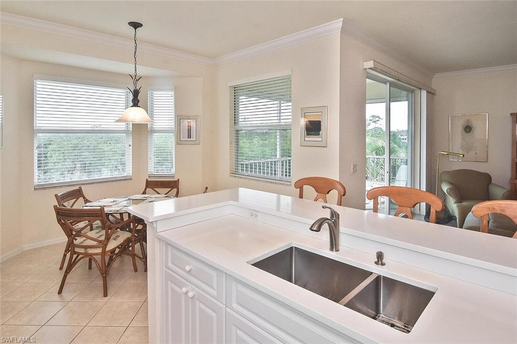 3830 Sawgrass Way, Unit 2946 Naples, FL 34112 - Photo 29 of 49 a kitchen with a dining table and chairs