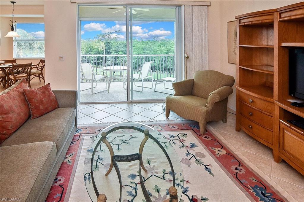 3830 Sawgrass Way, Unit 2946 Naples, FL 34112 - Photo 35 of 49 a living room with furniture and a floor to ceiling window