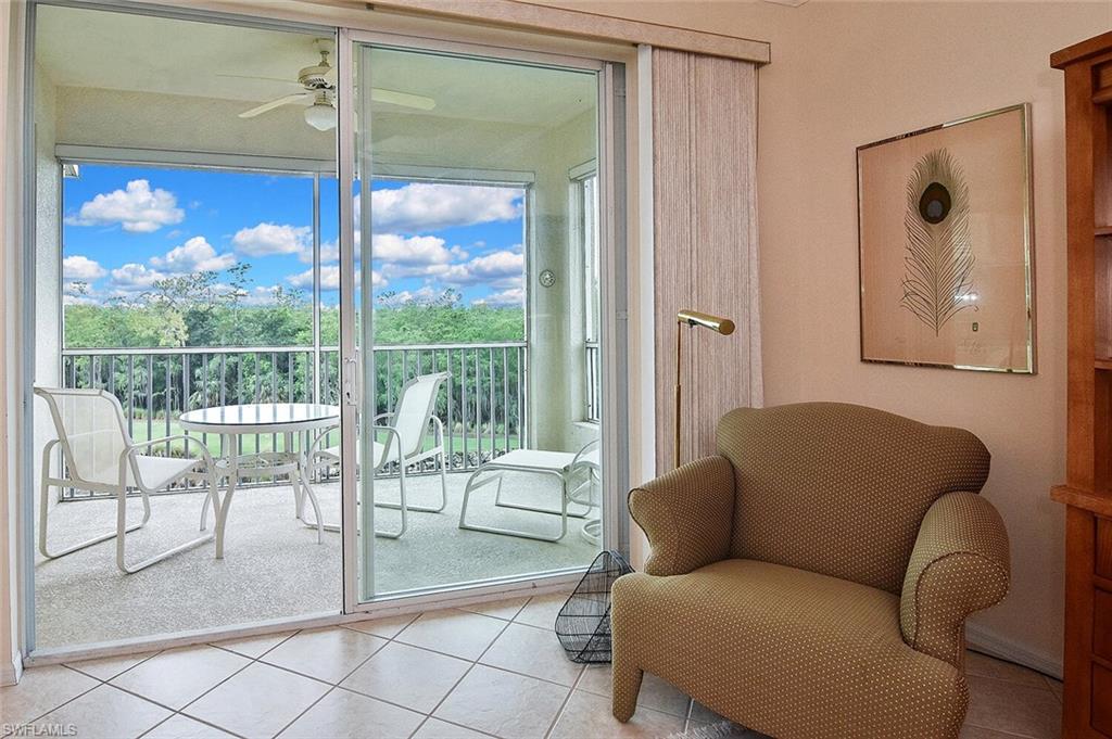 3830 Sawgrass Way, Unit 2946 Naples, FL 34112 - Photo 36 of 49 a living room with furniture and a floor to ceiling window
