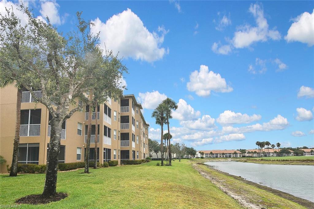 3830 Sawgrass Way, Unit 2946 Naples, FL 34112 - Photo 43 of 49 a view of a lake with a building in the background