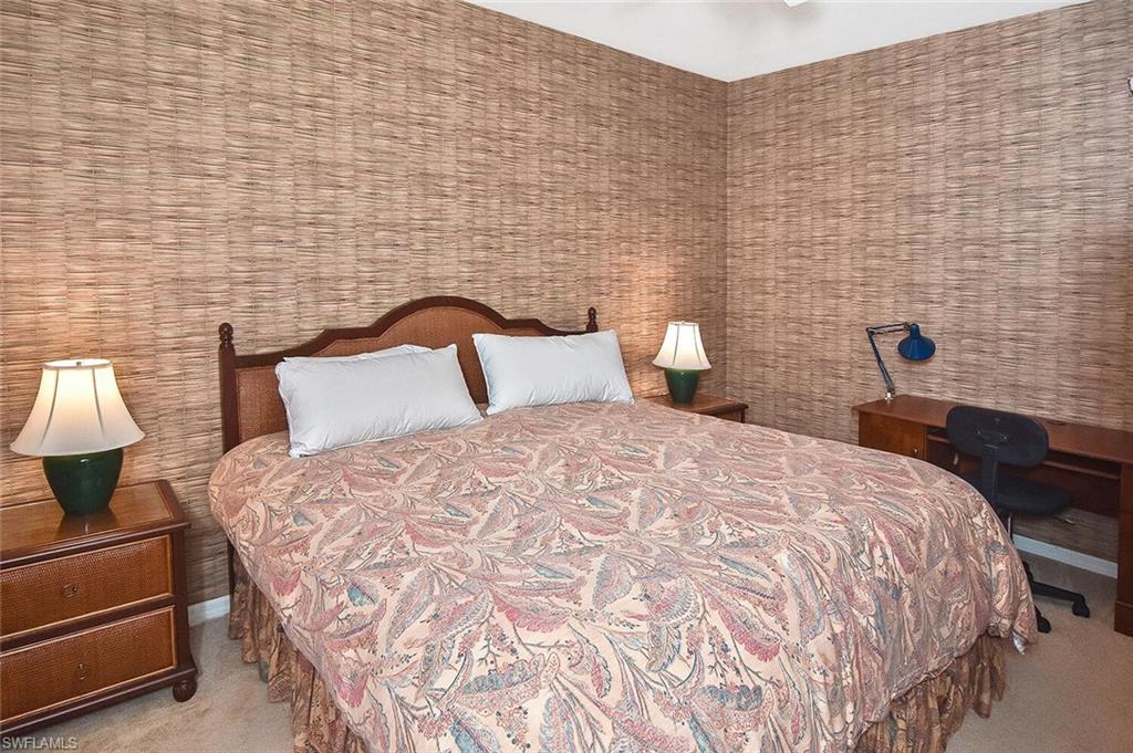 3830 Sawgrass Way, Unit 2946 Naples, FL 34112 - Photo 6 of 49 a bedroom with a bed and a lamp