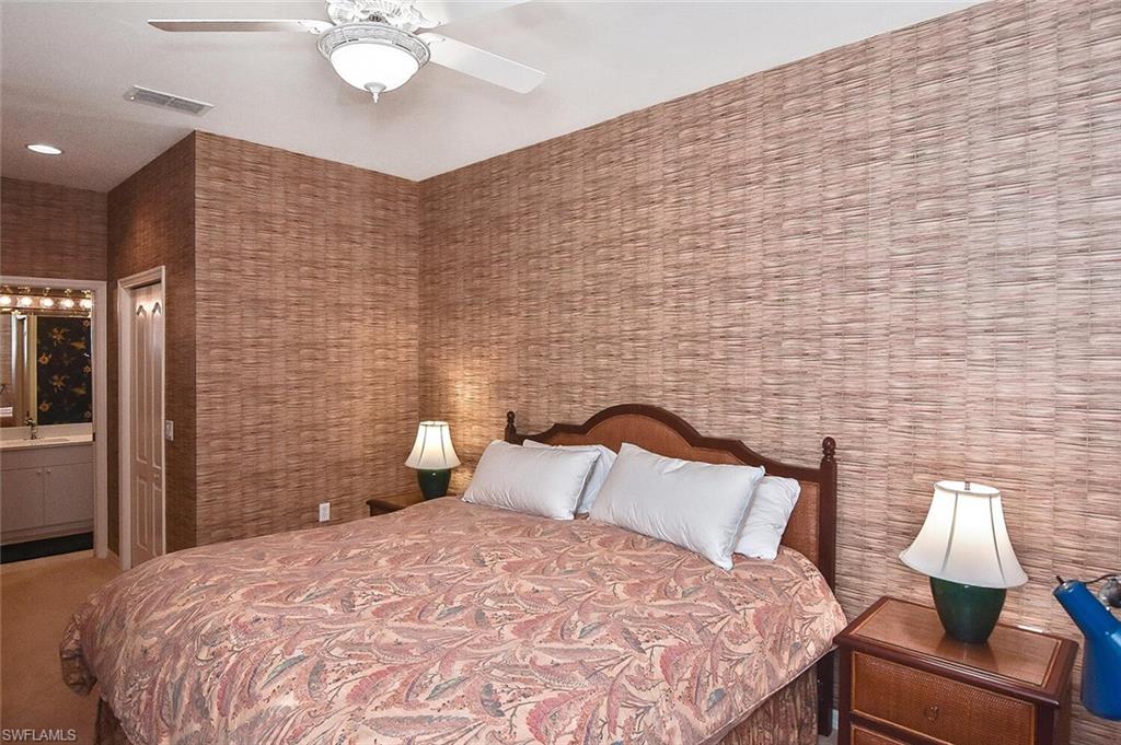 3830 Sawgrass Way, Unit 2946 Naples, FL 34112 - Photo 7 of 49 a bedroom with a bed and a lamp