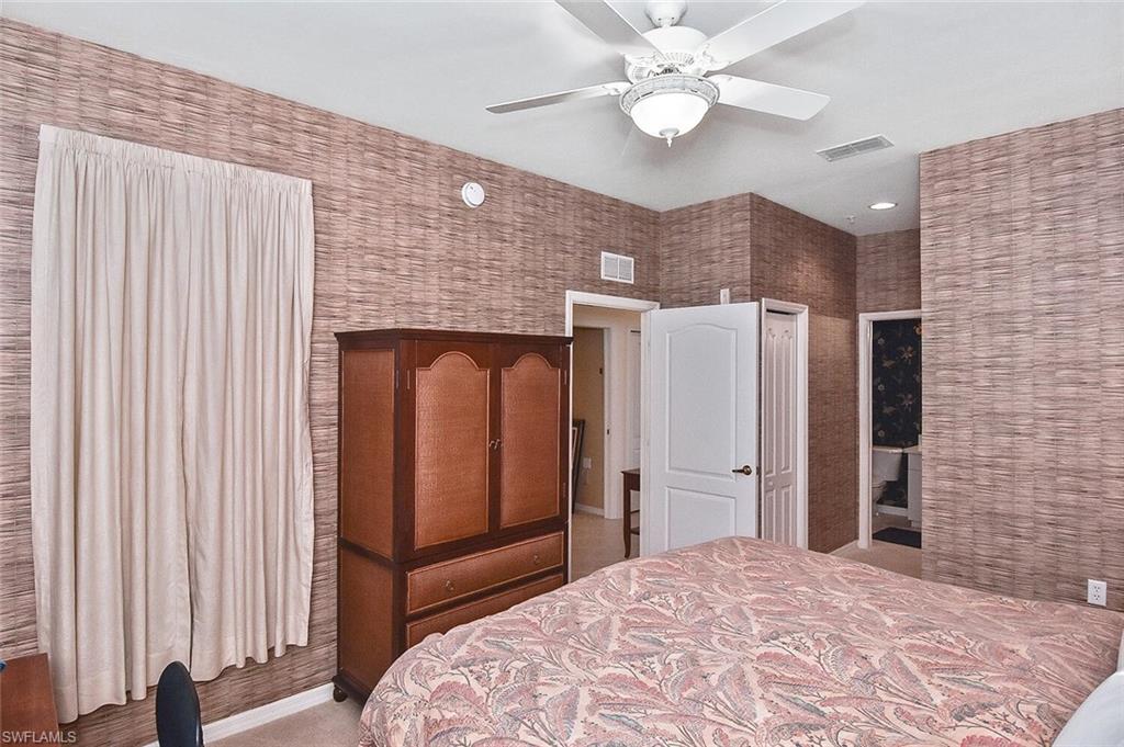 3830 Sawgrass Way, Unit 2946 Naples, FL 34112 - Photo 8 of 49 a bedroom with a bed and a chandelier