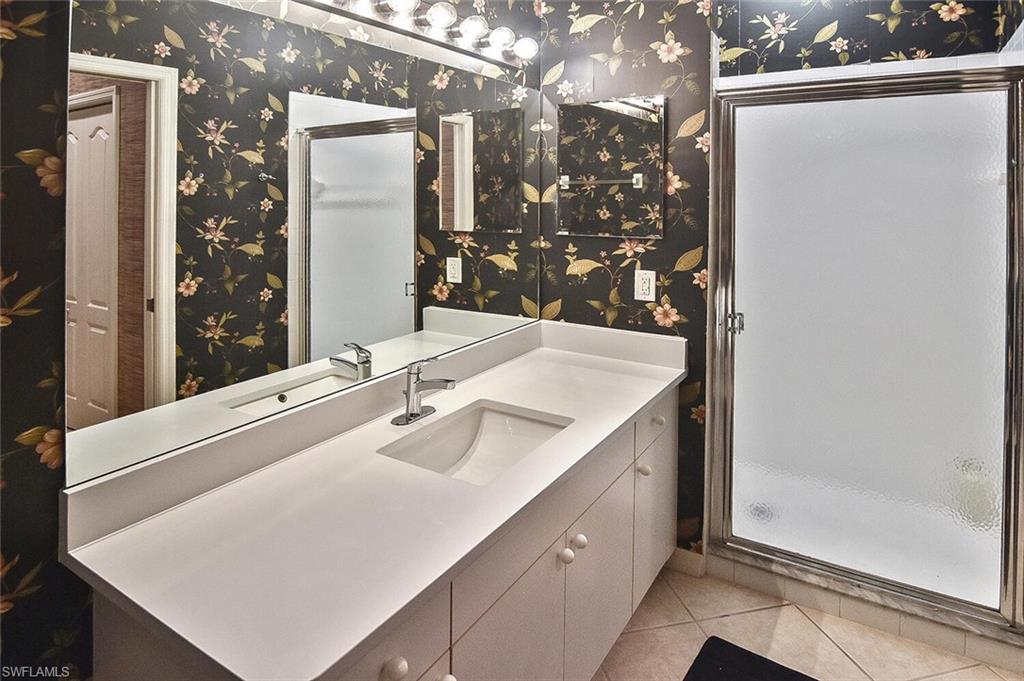 3830 Sawgrass Way, Unit 2946 Naples, FL 34112 - Photo 10 of 49 a bathroom with a sink and mirror