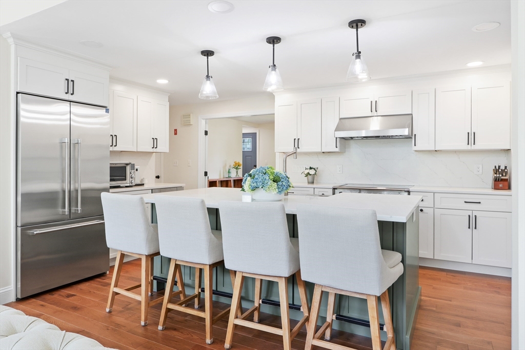 247 Greendale Avenue Needham, MA 02494 - Photo 4 of 33 a kitchen with stainless steel appliances granite countertop a dining table chairs refrigerator and microwave