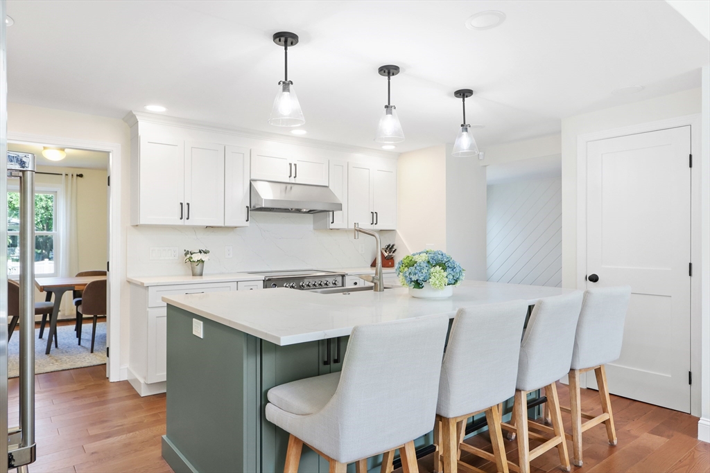 247 Greendale Avenue Needham, MA 02494 - Photo 5 of 33 a kitchen with stainless steel appliances kitchen island granite countertop a dining table chairs and white cabinets