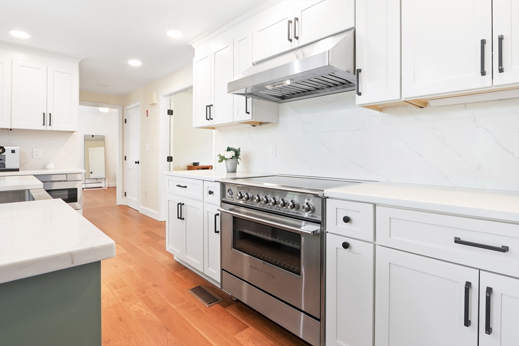 247 Greendale Avenue Needham, MA 02494 - Photo 6 of 33 a kitchen with stainless steel appliances a stove a sink and white cabinets