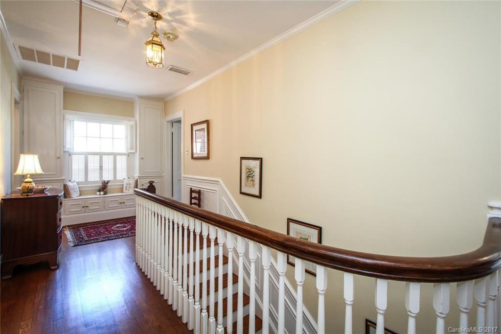 1245 Providence Road Charlotte, NC 28207 - Photo 13 of 24 a view of a hallway to a livingroom with furniture wooden floor windows and a chandelier