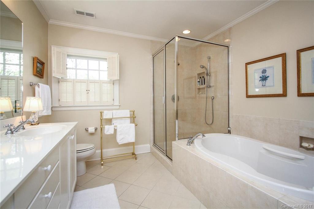 1245 Providence Road Charlotte, NC 28207 - Photo 18 of 24 a bathroom with a tub sink toilet and a window