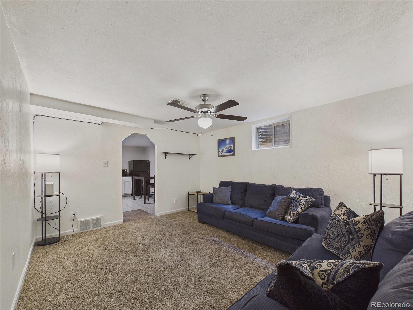 3358 Pontiac Street Denver, CO 80207 - Photo 14 of 26 a living room with furniture and a chandelier